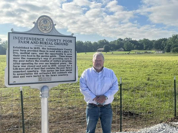 County Judge Kevin Jeffrey next to new historical marker for Independence County Poor Farm